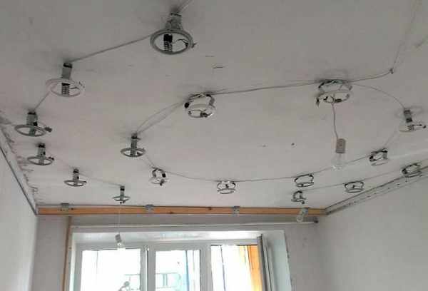 Установленные под натяжным потолком стойки для точечных светильников