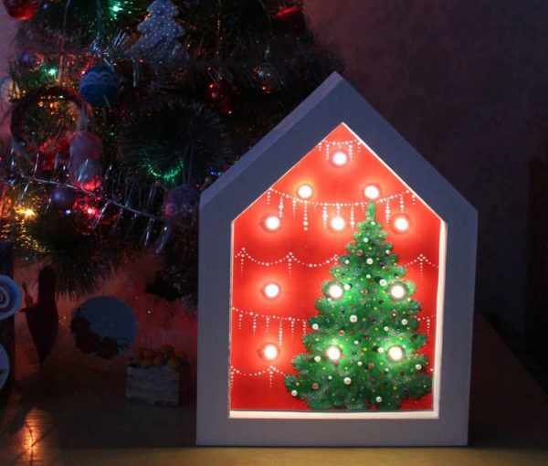 Светильник в виде домика под новогодней елкой